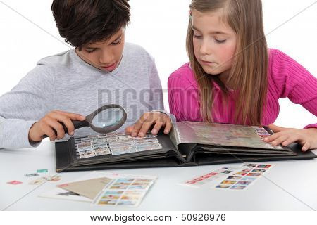Kids looking at a stamp album