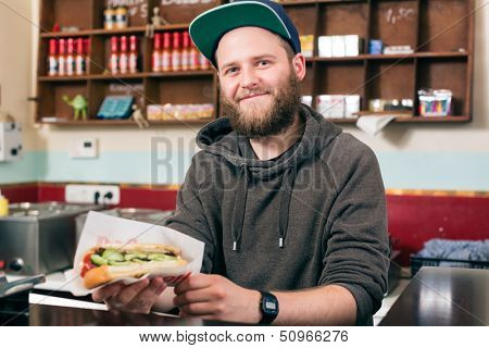 Hotdog - friendly salesman and customer in a fast food snack bar