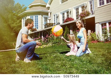 Happy smiling family with child over  house background