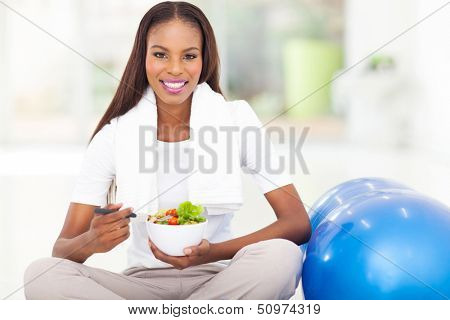attrative african woman eating healthy salad at home