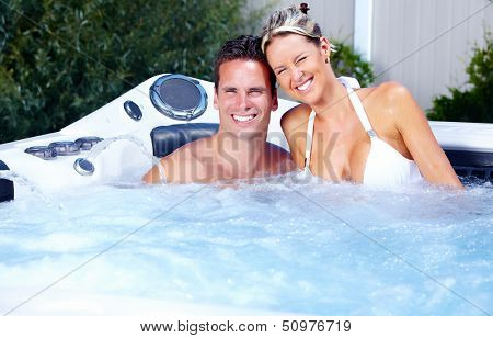 Happy couple relaxing in hot tub. Vacation.