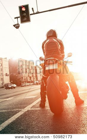 motorcyclist on the road with the setting sun