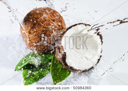 cracked coconut with big splash, isolated on white