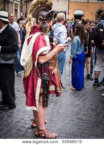 Roman soldier sending a text message at the Trevi Fountain in full regalia