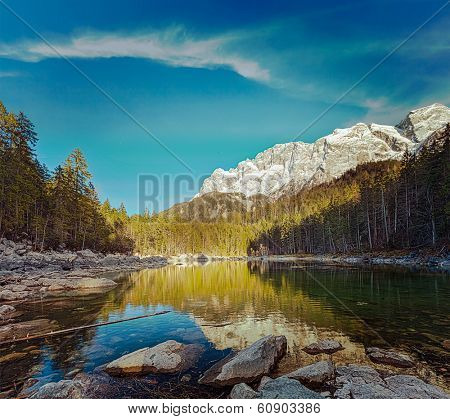 Vintage retro hipster style travel image of Frillensee (small lake near Eibsee) and Zugspitze - the highest mountain in Germany