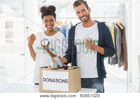 Portrait of a smiling young couple with donation box