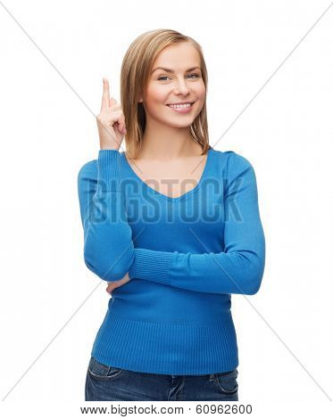advertisement concept - attractive young woman in casual clothes pointing her finger up