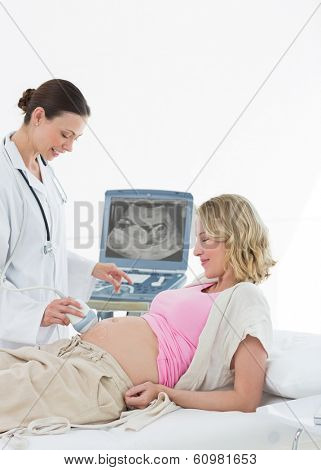 Female doctor performing ultrasound on pregnant woman in clinic