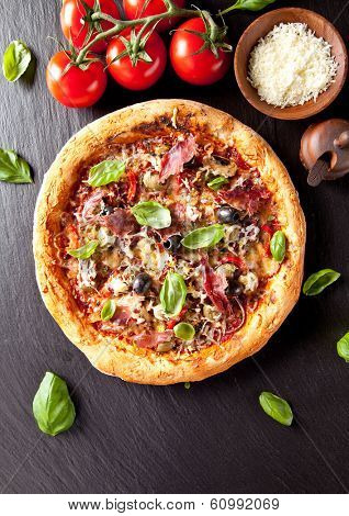 Home made fresh italian pizza with vegetable. Served on black stone surface.