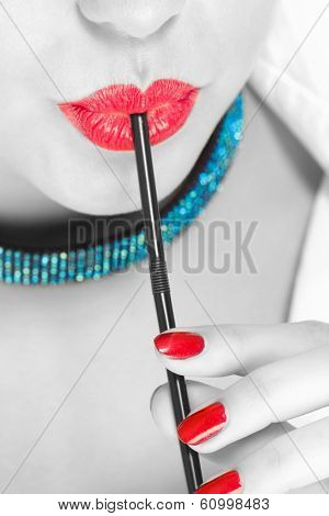 close up of woman drinking cocktail through straw