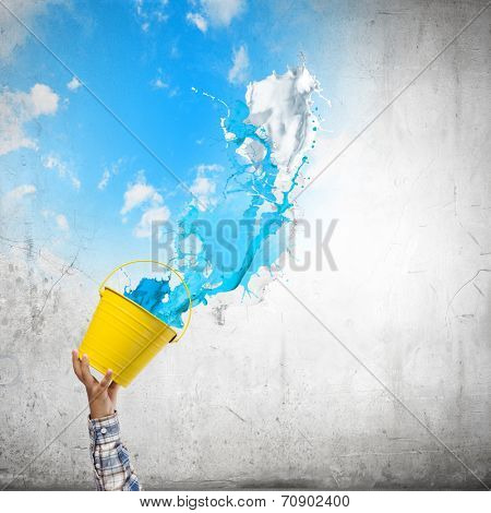 Close up of hand splashing colorful paint from bucket