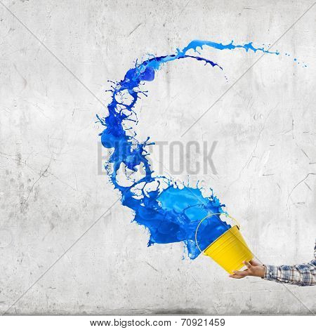 Close up of hand splashing colorful paint from bucket