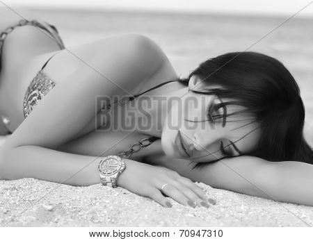 Beautiful nude brunette posing on the beach