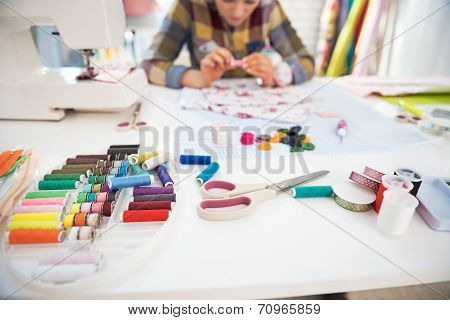Closeup On Working Desk And Tailor Woman In Background