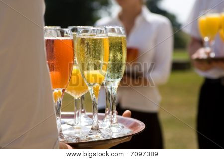 Serveuse tenant un plateau de boissons avec coupes de Champagne