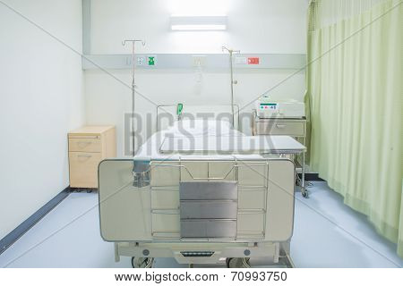 A Hospital Room With Bed And Chair