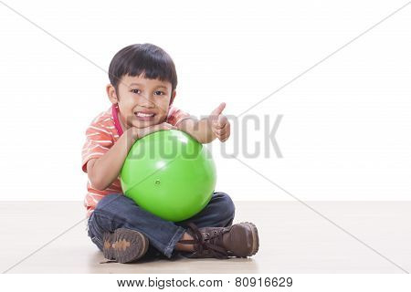 Cute little boy playing green ball