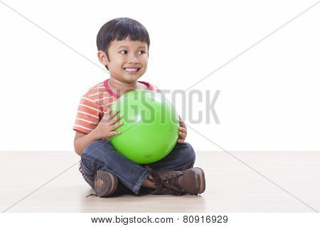 Cute little boy playing green ball