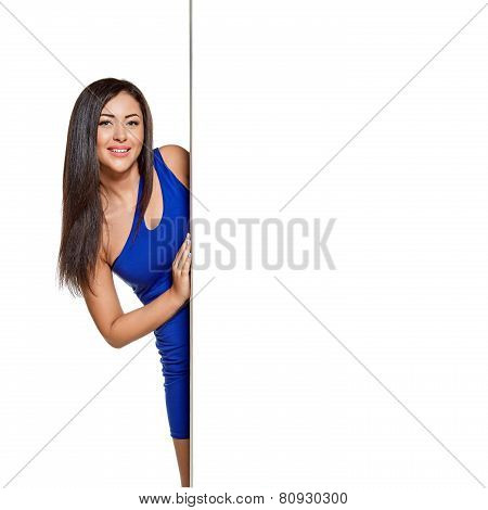 Young pretty woman peeking out from behind the wall
