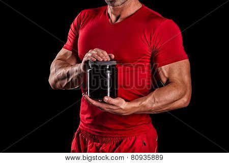 Sport, Bodybuilding, Strength And People Concept - Young Man Standing Holding Jar With Protein Over