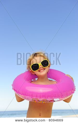 Child With Sunglasses And Inflatable Ring At The Beach