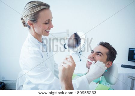 Female dentist brushing mans teeth in the dentists chair