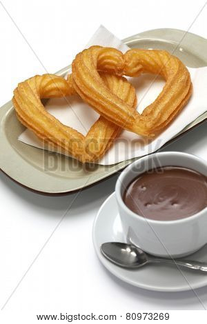 heart shape churros and hot chocolate on white background