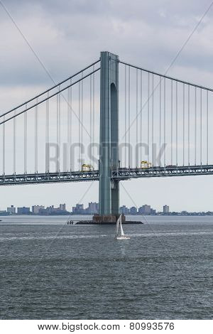White Sailboat Under Suspension Bridge