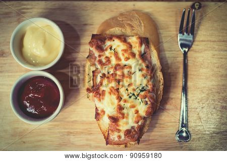 Bread Baked With Cheese Served With Tomato Sauce, And Chili Sauce.