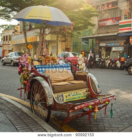 Penang, Malaysia - February 25, 2015: An old traditional trishaw cab along a street in Penang, Malaysia.