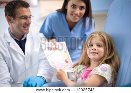 Young girl receive a commendation card for bravery at dental clinic 