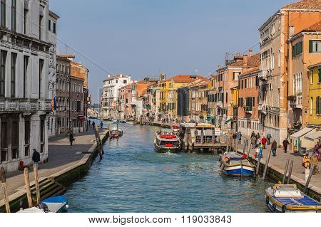 VENICE ITALY - 14TH MARCH 2015: Colourful buildings along Fondamenta Cannaregio in Venice during the day. People boats and shops can be seen.