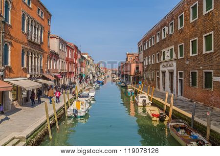 MURANO ITALY - 14TH MARCH 2015: A view along Fondamenta Dei Vetrai footpath in Murano during the day showing shops boats buildings and people