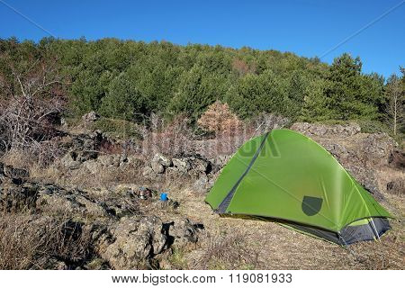 pinewood and green tent on glade of Etna National Park, Sicily