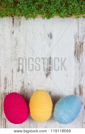 Easter Eggs Wrapped Woolen String And Green Cress On Wooden Background, Copy Space For Text, Decorat