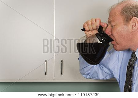 Businessman drinking out of coffee pot