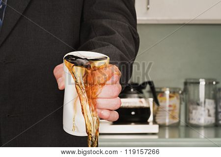 Businessman crushing coffee cup