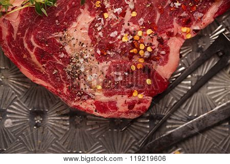 beef steak t-bone with vintage meat fork on metal backdrop