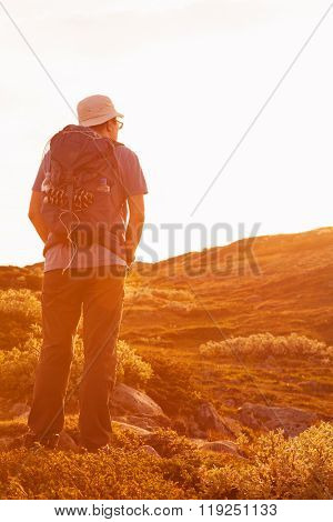 hiker with backpack traveling in Norway mountains Dovre