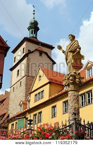 Rothenburg ob der Tauber in Germany. The White tower and the Seelbrunnen fountain on Chapel square. It embodies the Greek goddess Minerva the goddess of wisdom and patroness of the city.