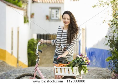 Beautiful female tourist living like a local, with her bicycle after buying some fresh vegetables