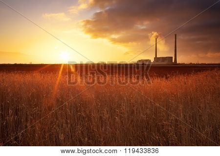 Beautifull landscape with thermal power plant reeds and sunset sky.
