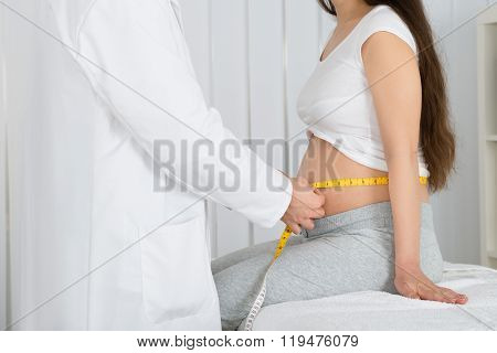 Doctor Checking Growth Of Baby In Clinic