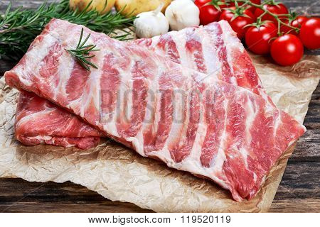 Raw  Pork ribs with a rosemary and vegetables.