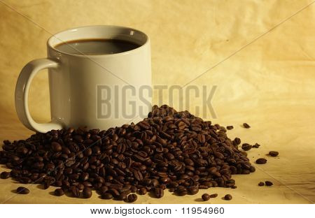 ถ้วยกาแฟในกองเมล็ดกาแฟร้อน