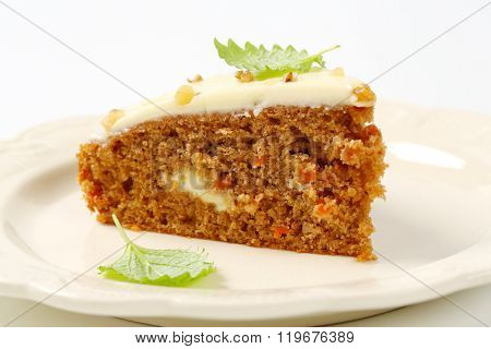 slice of gingerbread cake with cream cheese topping and chopped walnuts - close up