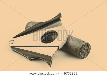 Expensive cigar and cutter on a white background
