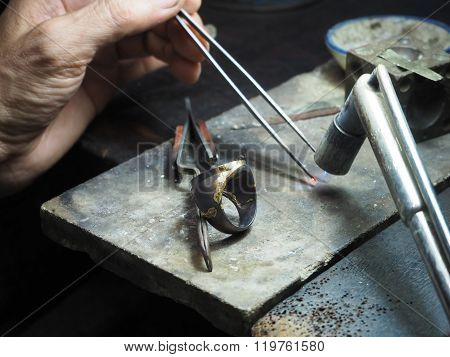 Goldsmith working on an unfinished  gold with his hard working hands