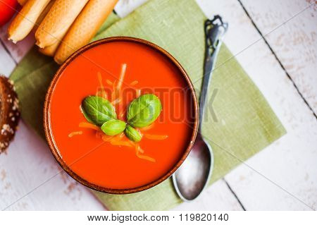 Tomatoe Soup With Bread Sticks And Basil On Wooden Background