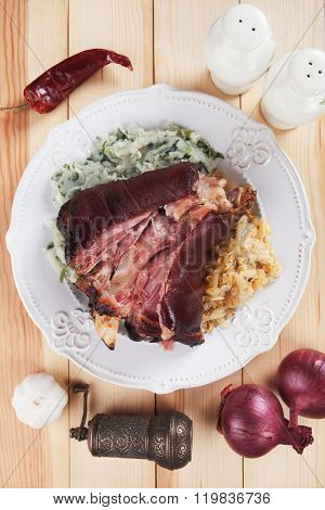Roasted pork knuckle with potato mash and sour cabbage or sauerkraut